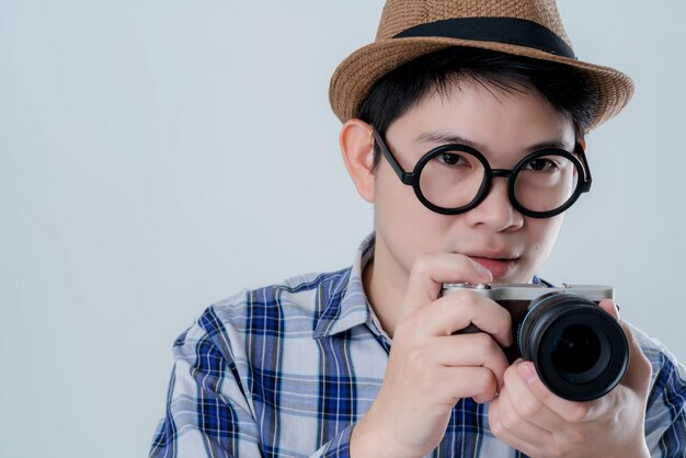 Curious glasses asiasn man with summer costume hand hold camera find something white background