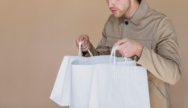 Curious man looking in shopping bags