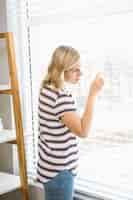 Free photo curious woman peeking out of a window