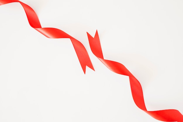 Curled red ribbons on white background