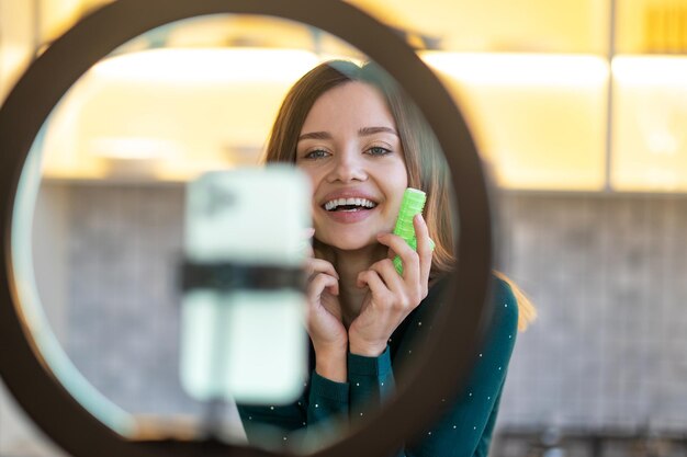 カーラー。カーラーでヘアスタイリングのヒントを示す笑顔の若い女性