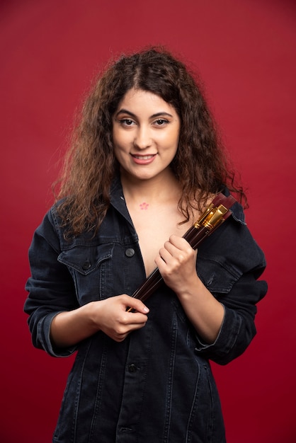 Curly artist holding paintbrushes.