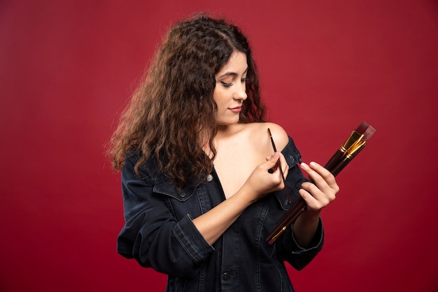 Curly artist painting herself.