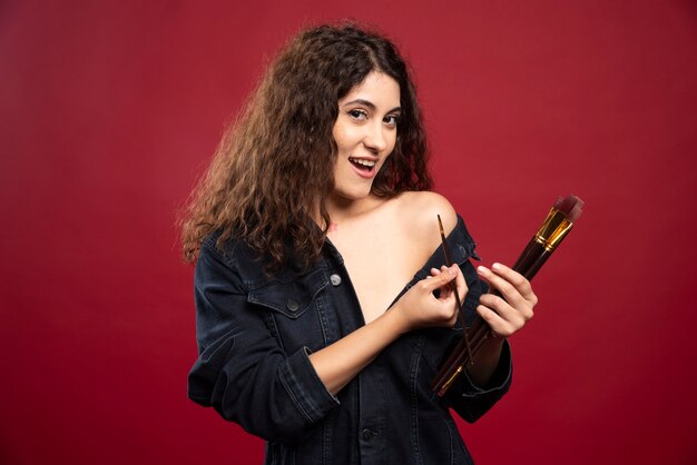 Curly artist painting herself.