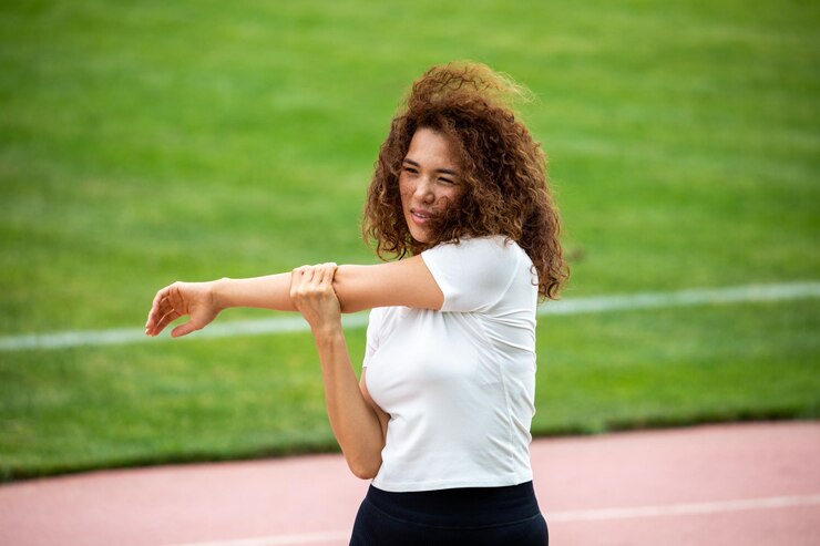 Free Photo curly beautiful asian girl in a white tshirt and black leggings plays sports on the football field