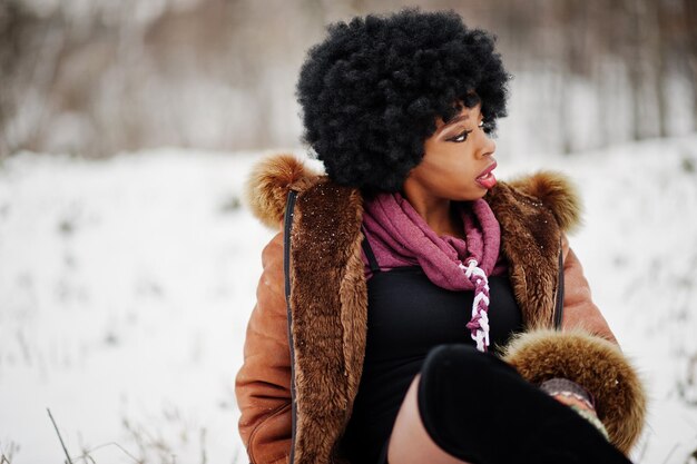 Curly hair african american woman wear on sheepskin coat and gloves posed at winter day