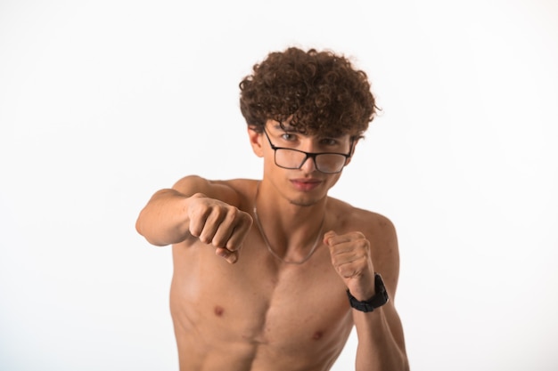 Curly hair boy in optique glasses boxing and training