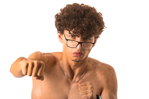 Curly hair boy in optique glasses punching with right hand on white background