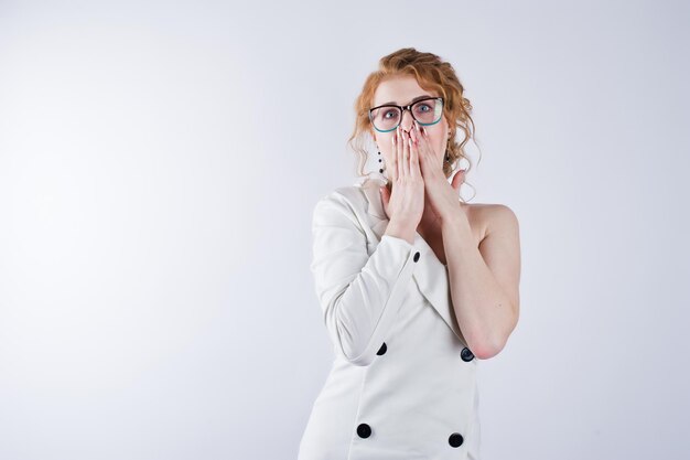 Capelli ricci ragazza faccia stupita in bicchieri isolati su sfondo bianco per studio