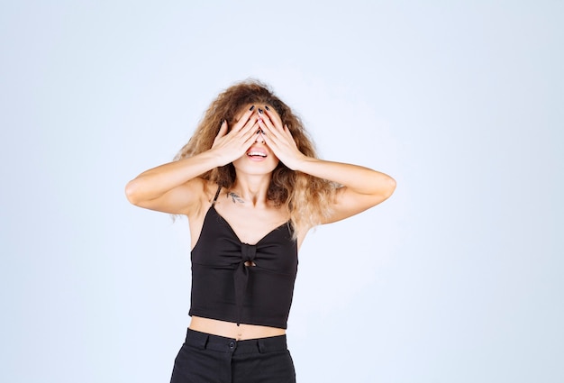 Free photo curly hair girl closing a part of her face with hand.