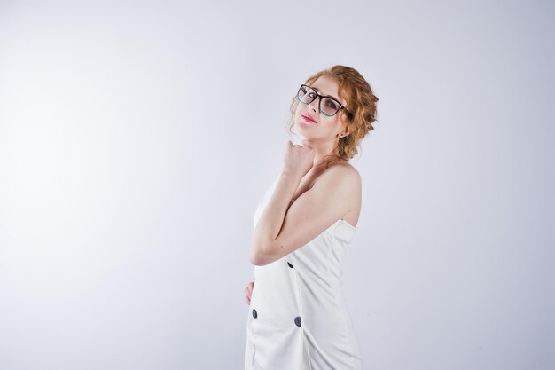 흰색 스튜디오 배경에 고립 된 안경에 곱슬 머리 소녀