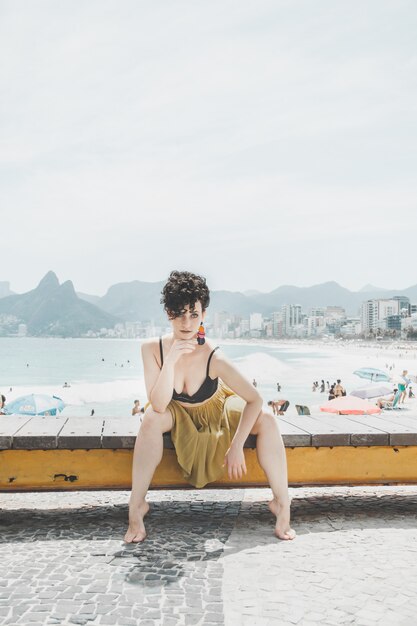 Curly hair model wearing an evening dress and posing on the promenade in Rio de Janeiro