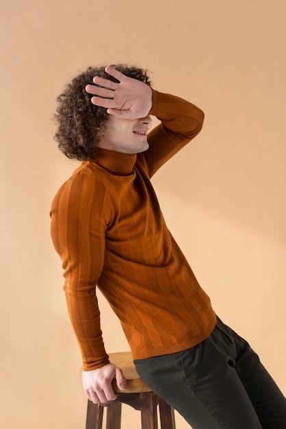 Free photo curly haired man with brown blouse posing