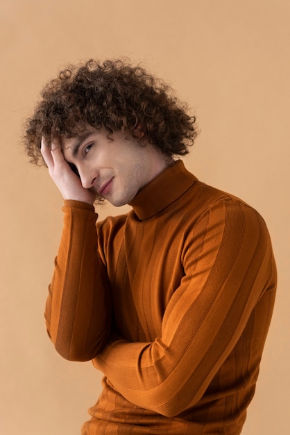 Free photo curly haired man with brown blouse posing