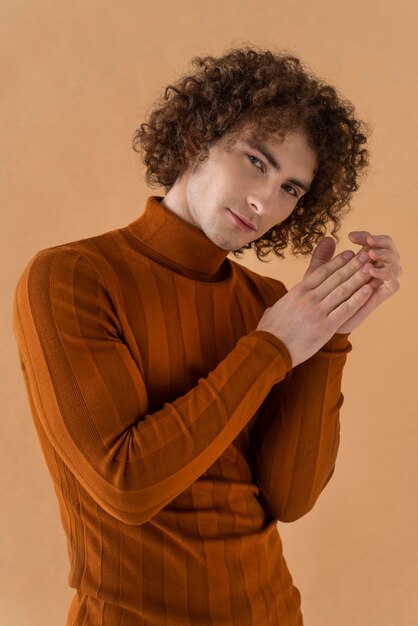 Curly haired man with brown blouse posing