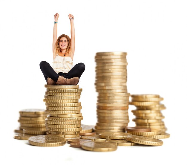Photo gratuite femme aux cheveux bouclés assise sur un tas de pièces de monnaie
