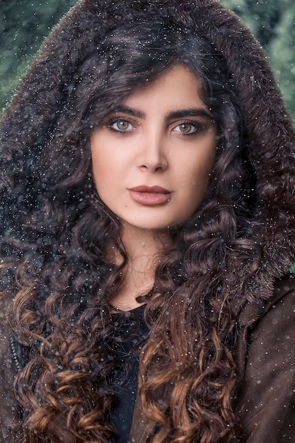 Curly haired woman wearing fur hoodie