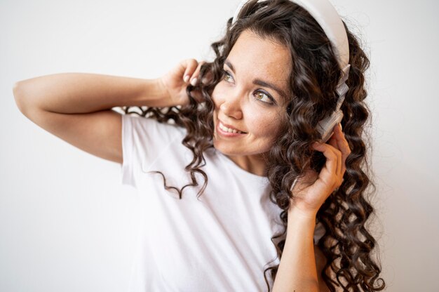 Curly woman listening to music close-up