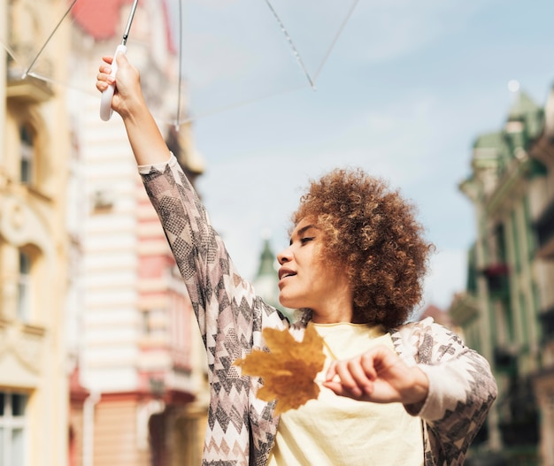 Free photo curly woman posing with an umbrella