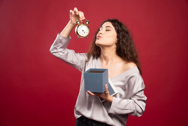 Curly young woman looking at clock.