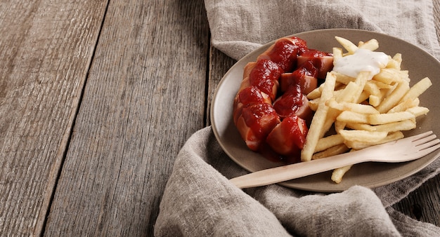 Free photo curry wurst with sauce and french fries