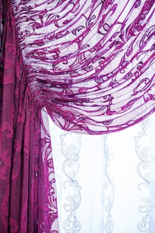 Образцы штор, висящие на вешалках на рельсах в магазине. выбор образцов текстуры ткани ткани для внутренней отделки шторы, тюль и обивка мебели.