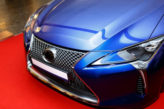 Curved blue sports car hood showing an abstract reflection. 