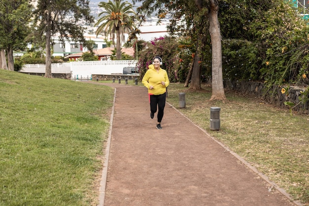 都市​公園​で​屋外​で​ジョギング​ルーチン​を​している​曲線美​の​女性​-顔​に​焦点​を​当てる