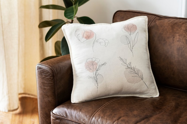 Cushion with minimal floral line art on a leather couch