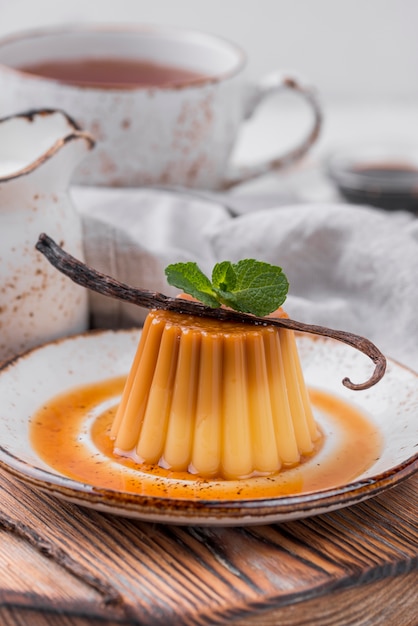 Бесплатное фото Заварной крем на тарелке с мятой и стручком ванили