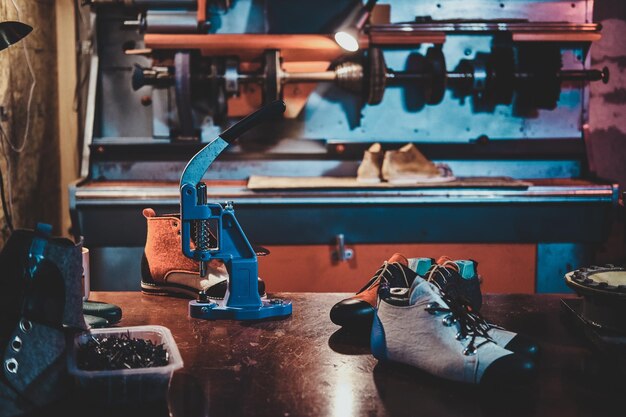 바쁜 구두 장인의 작업장에 있는 탁자 위에 있는 맞춤형 수제 신발.