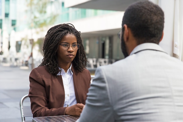 Customer consulting professional in outdoor cafe