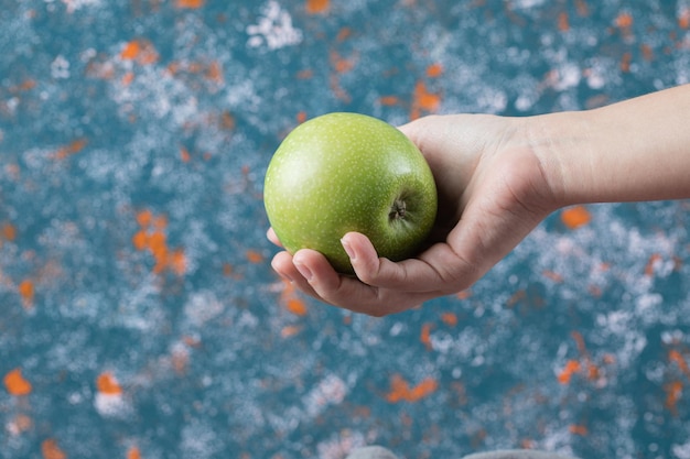 Free photo customer holding an apple on hand.