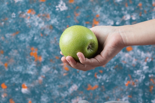 Клиент держит яблоко под рукой.