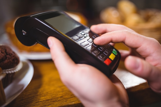 Customer making payment through payment terminal at counter