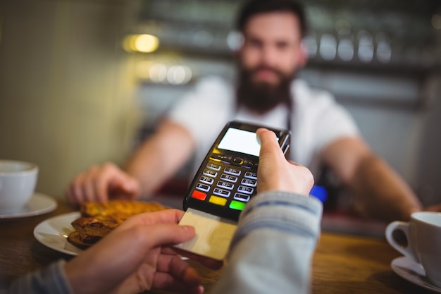 Customer making payment through payment terminal at counter