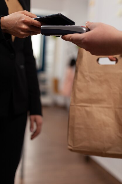 Customer paying for their order with smartphone nfc technology