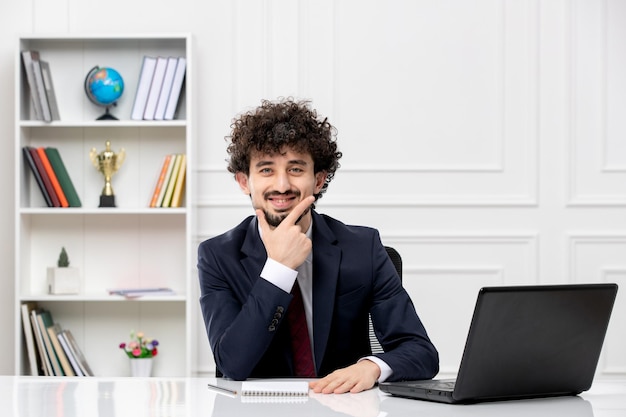 Обслуживание клиентов кудрявый брюнет молодой человек в офисном костюме и красном галстуке с ноутбуком счастливо улыбается