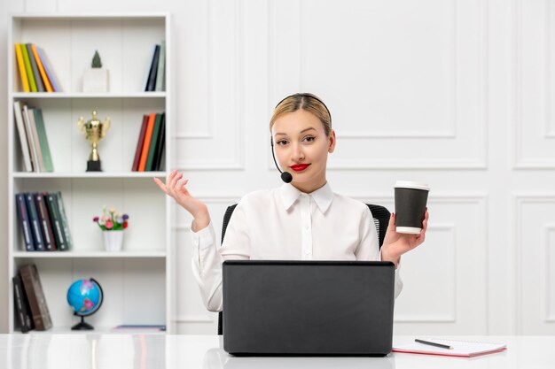 Customer service cute blonde girl office shirt with headset and computer holding a coffee cup