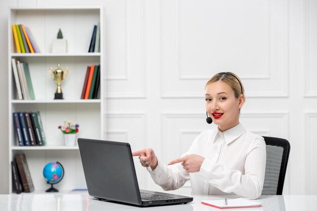 헤드셋과 컴퓨터가 귀엽게 웃고 있는 고객 서비스 귀여운 금발 소녀 사무실 셔츠