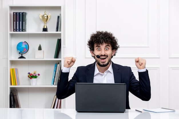 Customer service cute brunette guy in office suit with computer and headset super excited