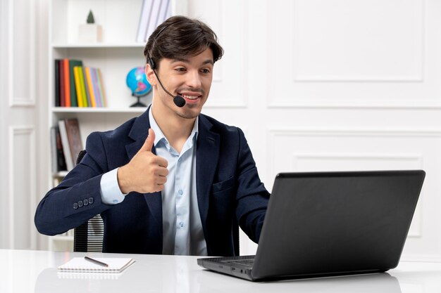 Customer service handsome guy with headset and laptop in suit showing good gesture