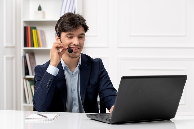 Customer service handsome guy with headset and laptop in suit talking on videocall