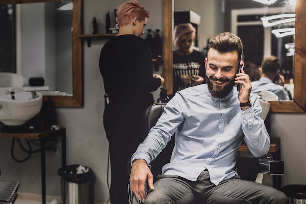 Cliente che parla sul telefono nel barbiere