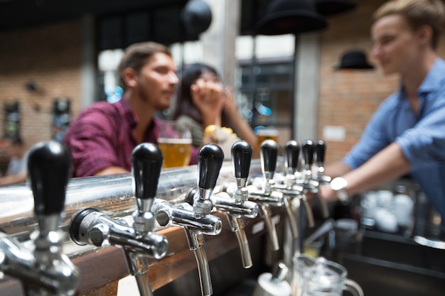 Clienti, barman e birra in pub