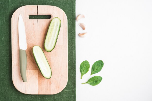 Cut cucumber near spinach and garlic