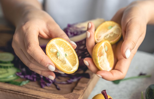 Free photo cut limequat in a female hands preparing salad in the kitchen