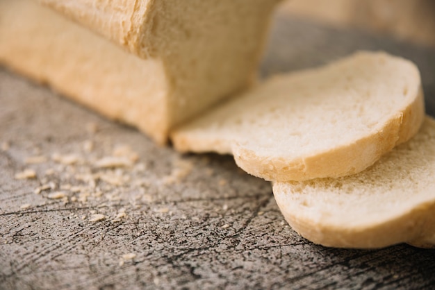 Cut loaf of white bread on grey table