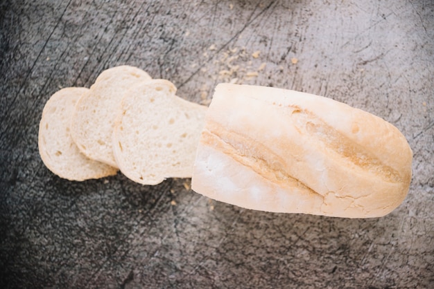 Cut loaf of white bread on table