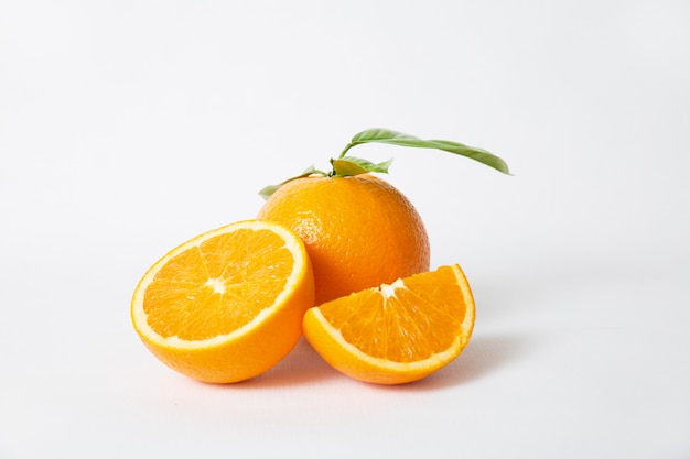 Cut orange parts and whole fruit with green leaves